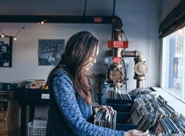 Woman working in a record store that is launching online