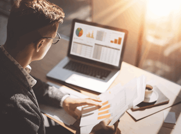 Man using a laptop to look at review charts