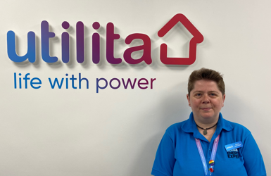 Utilita employee standing in front of Utilita sign